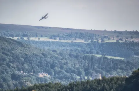 Villager Jim Lancaster Bomber flying over Chatsworth House, in Derbyshire