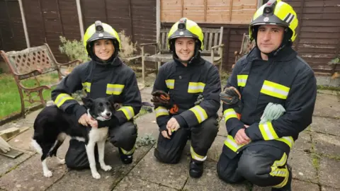 Elsie Emery Firefighter Elsie Emery with her team and a dog