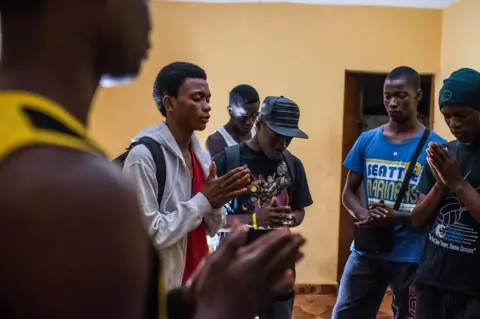 Olivia Acland The group pray before a performance