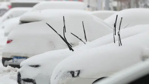 Getty Images Snow-covered vehicles are seen after a snowfall on November 9, 2021 in Shenyang