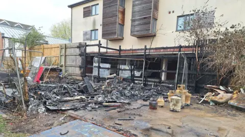 BBC Charred remains of the caravan close to new block of flats in Bristol