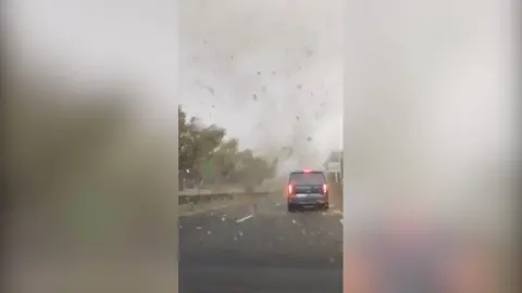 Car passengers videos tornado in distance