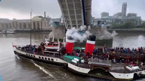 A sea-going paddle steamer passes nether  London's Tower Bridge