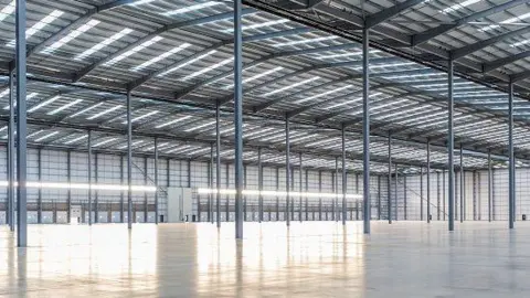 Logicor The inside of a warehouse, showing metal pillars and roof structure, grey walls and shiny floor