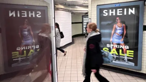  A person walks past an advertisement for Shein, in London.