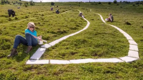 Volunteers painting The Long Man of Wilmington 