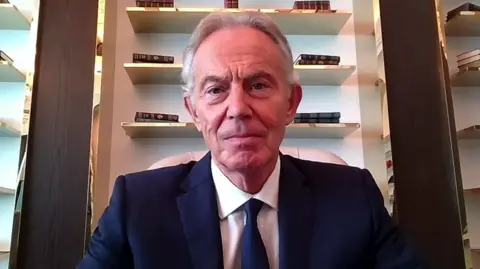 Tony Blair wearing a navy blue suit 