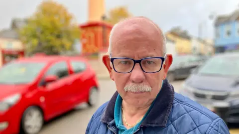 Councillor Haydn Trollope, wearing a blue coat, standing in Tredegar and looking at the camera