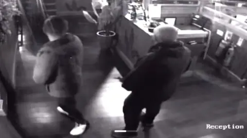 CCTV footage of the inside of their restaurant with the back of two men in forefront