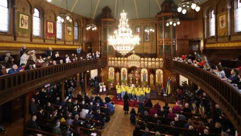 EPA Children from St Mary's Ukrainian School sing during an interfaith prayer service for peace in Ukraine at the Ukrainian Catholic Cathedral.