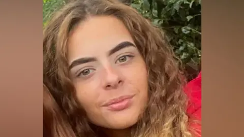 A close-up photograph shows Alisha Ponter with long hair looking towards the camera outdoors. The image focuses on her face and shoulders and is cropped from a larger photograph.