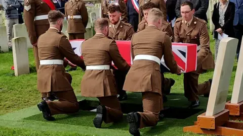 Soldiers lower 2nd Lt Greenhalgh's coffin into the ground