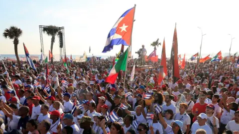 People march with Cuban flags in Havana on May Day.