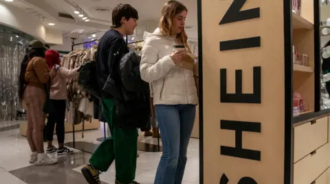 Reuters Shoppers looking at Shein products