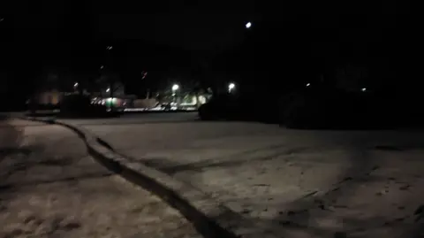 Tracks and footprints on the surface of a frozen lake at night