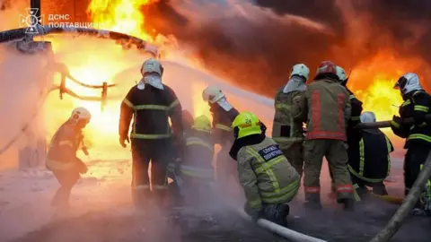 firefighters battle flames at the sit of a Russian strike