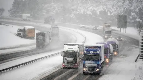 Getty Images Vehicles travel down the M74, following motorist spending the night stranded on the motorway on January 17, 2018 in Abington, Scotland.