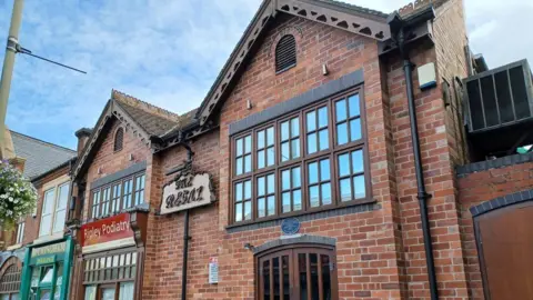 A photograph of the Regal nightclub where the assault happened. It is a red brick building with dark wooden windows.