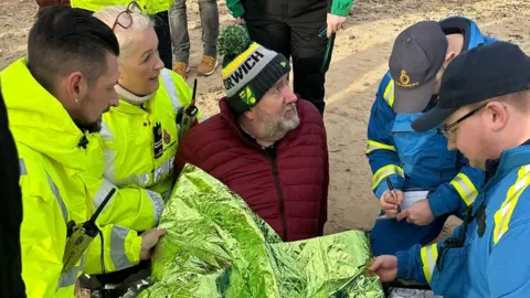 Andrew Goldson Mr Goldson being assessed by paramedics on the beach.