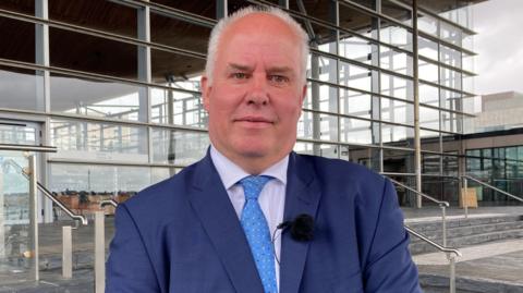 Andrew RT Davies stood outside the Welsh Parliament on the Senedd steps in Cardiff Bay.
