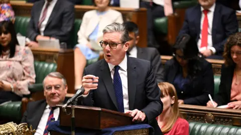 Prime Minister Sir Keir Starmer stands and points in the House of Commons.
