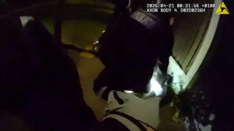 Police officer on the ground arresting a suspect.