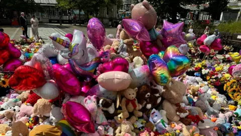 BBC A close up shot of balloons and flowers and teddies