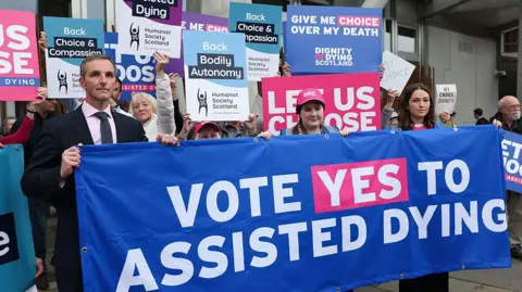 Getty Images Liam McArthur meets with supporters of a law change on assisted dying as they demonstrate outside the Scottish Parliament to show support for Stage 1 of Scotland’s assisted dying bill on May 13, 2025