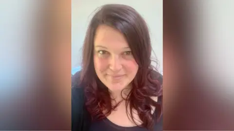 Handout Headshot picture of Jennie who has long brown hair and is wearing a black top