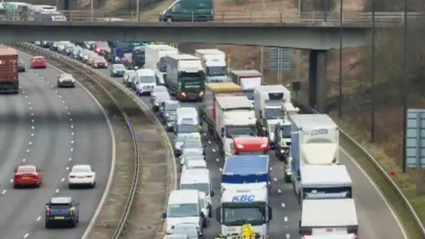 Cars and lorries at a standstill on side of M62 