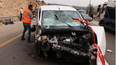 Reuters Israeli personnel and crashed vehicle at scene of Ariel attack (15/11/22)