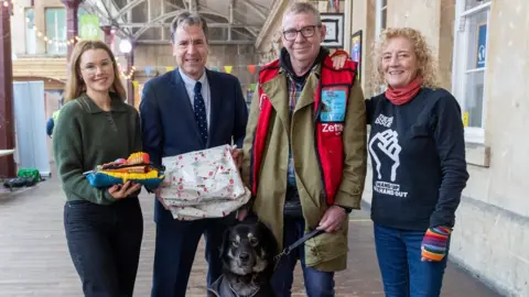 West of England Mayor  A group of people posing with a dog getting a parcel