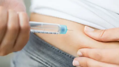 Getty Images girl with diabetes injecting insulin