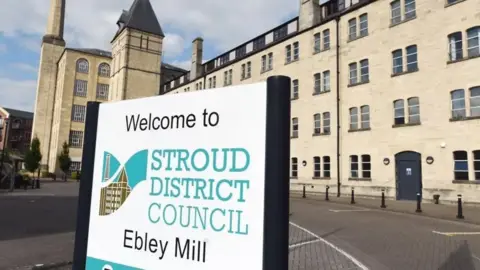Stroud district council sign in the foreground. Grey councils buildings in the background.