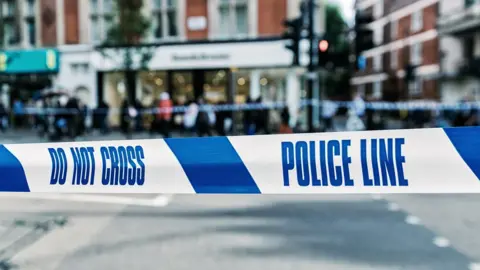 Getty Images Police Line tape at a street crime scene