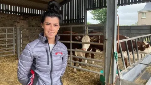 BBC Non Thorne in front of her cows