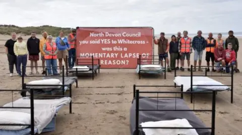 Liz Seymour Campaigners on the beach with a big sign