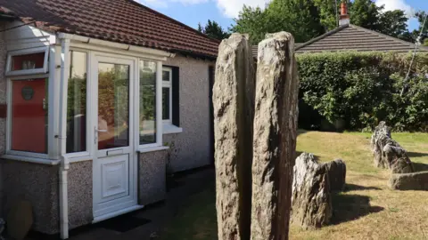 Two large standing stones, split down the middle, leaving a large gap between them 