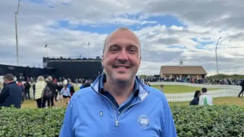 Colin Johnston in light blue top, at the Open at Royal Portrush, with spectators in the background.