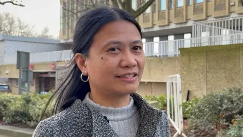 PA Media Apple Moorhouse, who has long black hair and is wearing a grey coat with grey jumper underneath, speaks outside Bradford Magistrates' Court.