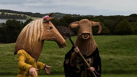 Charles McQuillan/Getty Images Three members of the Armagh Rhymers performning in a field in Castleward, County Down on September 16, 2018.  They are dressed up in their woven head pieces and period costume for a Game of Thrones-themed event. 