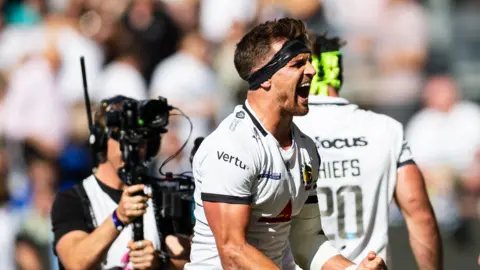 Henry Slade clenches his fist and has his mouth open in celebration