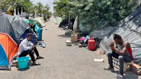 African migrants outside tents on a street in Tunisia