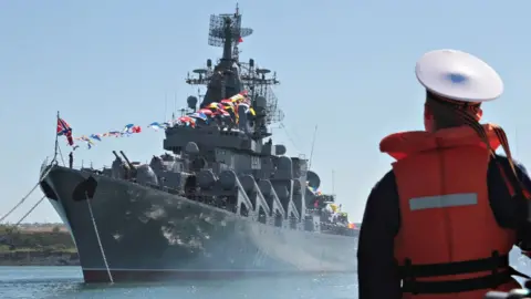 Reuters Sailor looks at Russian missile cruiser