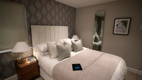 Getty Images An infrared wall panel that doubles as a mirror and heated skirting boards are seen in one of the research and testing homes built inside the Energy House 2 research facility at Salford University