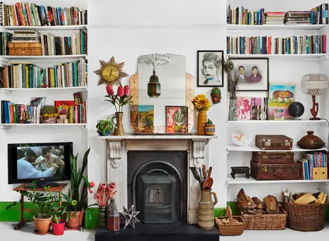 Zineb Sedira A photo by Zineb Sedira showing a living room with lots of personal possessions