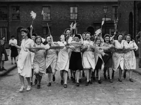 Getty Images Workers celebrate in the street
