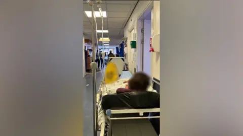 Family Handout A patient on a trolley in a hospital corridor