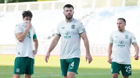 Hibernian's Joe Newell, Grant Hanley and Felix Passlack looks dejected following a 2-0 defeat during a UEFA Conference League Second Qualifying Round First Leg match between KF Malisheva and Hibernian at Fadil Vokrri Stadium, on July 23, 2026 in Pristina, Kosovo
