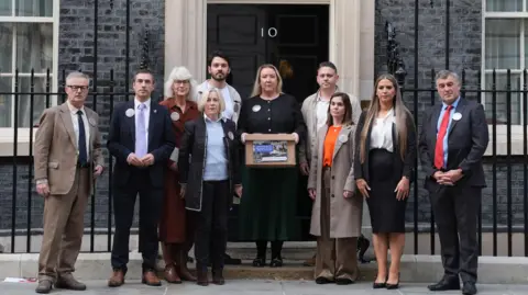 PA Media Representatives from the Chinook Justice Campaign outside the front door of 10 Downing Street in October 2025.